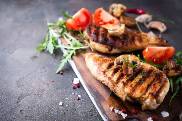 Grilled chicken dish with portobella mushroom served on a wooden board with fresh herbs and tomatoes at Gabriel's Gate Allen Street Buffalo NY