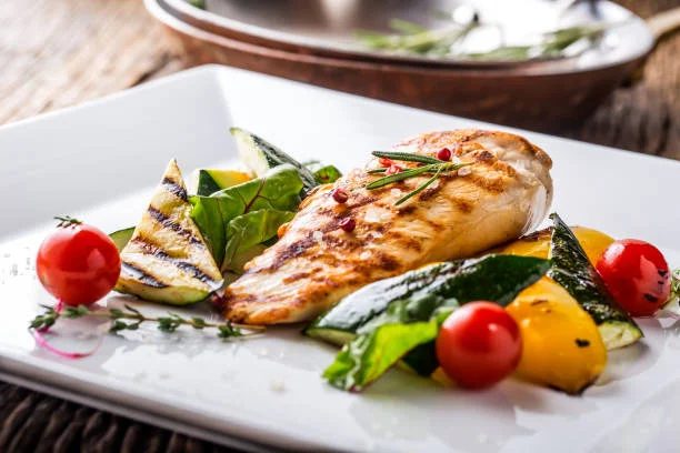 Grilled chicken breast served with fresh seasonal vegetables including tomatoes, zucchini and herbs at Gabriel's Gate restaurant Allentown Buffalo