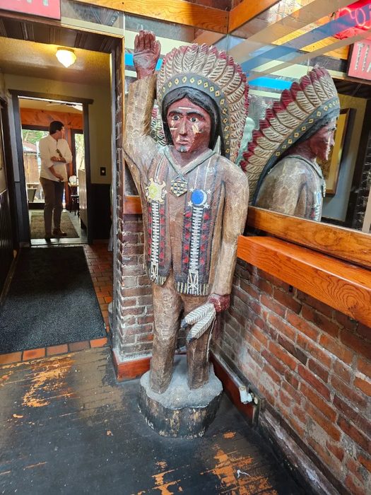 Historic carved and painted wooden Native American statue standing at the entrance vestibule of Gabriel's Gate restaurant on Allen Street Buffalo NY